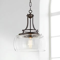 a glass light fixture hanging from a ceiling