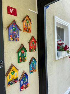 several colorful houses are hanging on the wall