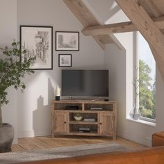 a living room with an entertainment center in the corner and pictures hanging on the wall