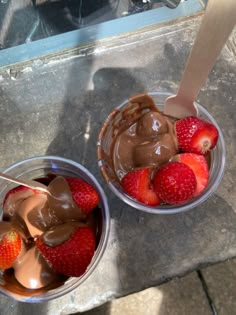 two plastic bowls filled with chocolate and strawberries