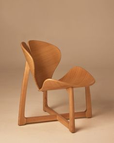 a wooden chair sitting on top of a white floor next to a brown wall in front of it