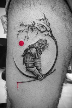 a man's leg with a tattoo on it and a red dot in the middle