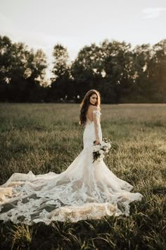 a woman in a wedding dress standing in the grass