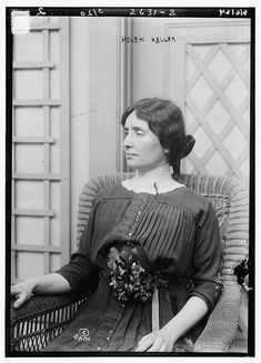 an old black and white photo of a woman sitting in a chair with her hand on her hip