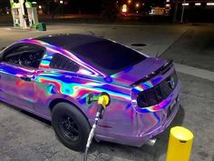 a car is painted with holographic paint and has a gas pump attached to it