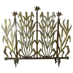 a metal fence with flowers and leaves on it's sides, against a white background