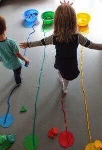 two young children playing with paper plates and streamers on the floor in front of them