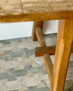 a wooden bench sitting on top of a tiled floor