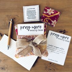 a notepad, pen and envelope on a wooden table with some writing paper next to it