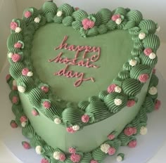 a heart shaped cake with pink and green frosting