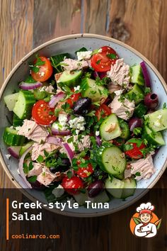 a salad with cucumbers, tomatoes, olives and tuna in a bowl