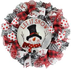 a wreath with a snowman on it that says let it snow and is attached to the front door