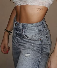 a woman's stomach with the word hope tattooed on her left side, in front of an unbuttoned pair of jeans