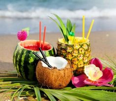 two pineapples, watermelon and strawberries on the beach