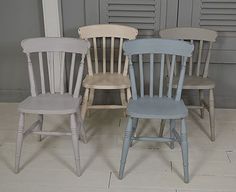 four wooden chairs sitting next to each other in front of shuttered windows and doors