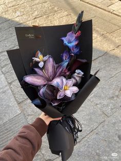 a person holding a bouquet of flowers on the street