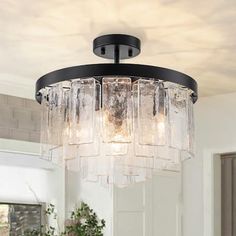 a chandelier hanging from the ceiling in a room with white walls and flooring