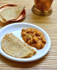 two tortillas on a white plate next to a small glass and a copper cup