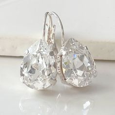 These gorgeous earrings display dazzling Swarovski clear crystal teardrops set in silver-plated bezels on gold lever back earrings.  Perfect for that special occasion! New Smaller Size- The photograph shows the small size compared to the larger pair Details: * Swarovski Crystal Clear Teardrops- 1/2x3/8"(14x10mm) * 925 Sterling Silver-plated Earrings * Length- 4/5"(20mm) * Nickel and Lead-free These earrings come in a jewelry bag and gift box. Cheap Hypoallergenic Crystal Drop Earrings, Classic Crystal Teardrop Earrings, Silver Teardrop Crystal Earrings, Silver Crystal Teardrop Earrings For Anniversary, Classic Sparkling Teardrop Crystal Earrings, White Crystal Teardrop Earrings, Pear-shaped Silver Crystal Earrings, Classic Teardrop Crystal Earrings, Classic Silver Crystal Teardrop Earrings