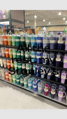 there are many different colors of coffee cups on the shelf in this store that is filled with all kinds of mugs