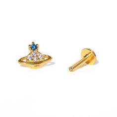 two pairs of gold earrings with blue and white stones on them, one in the shape of an alien head