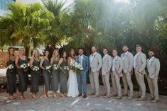 a group of people standing next to each other in front of some trees and bushes