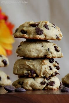 a stack of cookies sitting on top of a wooden table next to a vase with flowers