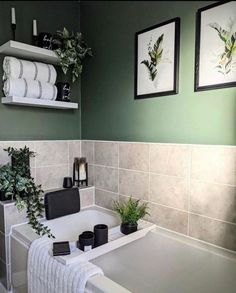 a white bath tub sitting under two framed pictures