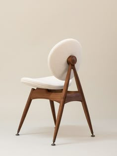 a chair with a wooden frame and white upholstered cushion on it's back