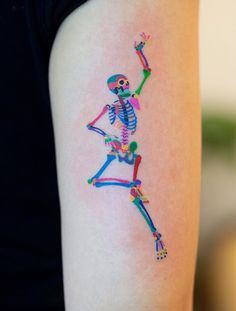 a woman with a colorful skeleton tattoo on her arm