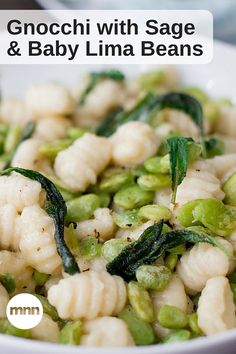 a white bowl filled with pasta and baby lima beans