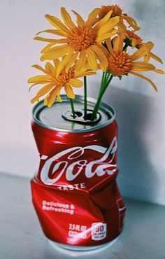 a can with flowers in it sitting on a table