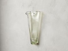 a glass vase is hanging on the wall next to a white stucco wall with no one in it