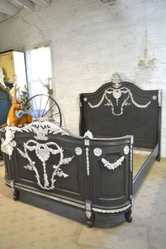 an old bed has been painted black with white designs on the headboard and foot board