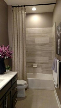 a bathroom with a sink, toilet and bathtub next to a shower curtain that has pink flowers on it