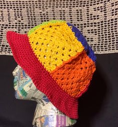 a multicolored crocheted hat sitting on top of a mannequin head