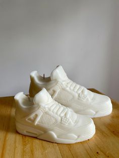 a pair of white sneakers sitting on top of a wooden table