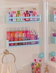 the bathroom is decorated in pink, blue and white with lots of bath products on shelves