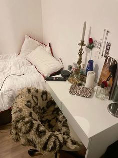 a white desk topped with a bed and a chair next to each other on top of a hard wood floor