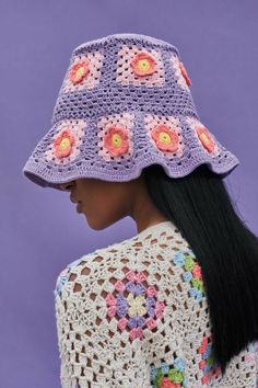 a woman wearing a crocheted hat with flowers on it