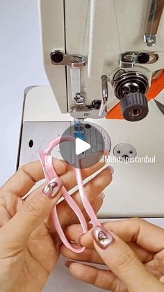 someone is using scissors to sew something on a sewing machine with the help of their hands