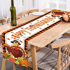 a happy thanksgiving table runner with a turkey and pumpkins on it, next to a bottle of wine