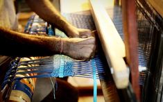 a man is weaving fabric on a loom