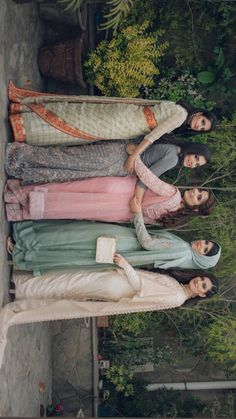 three women standing next to each other in dresses