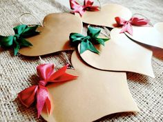 four paper hearts with bows on them sitting on a table