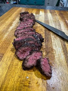 a piece of steak on a cutting board next to a knife