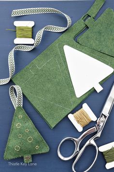 scissors, thread, and other crafting supplies laid out on a blue table top