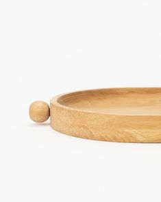 a wooden tray with a small round object on the bottom and a wood bead at the end