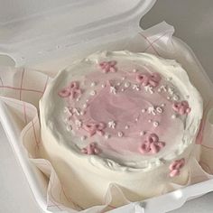 a cake in a white box with pink frosting