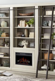 a living room filled with furniture and a fire place next to a bookcase full of books